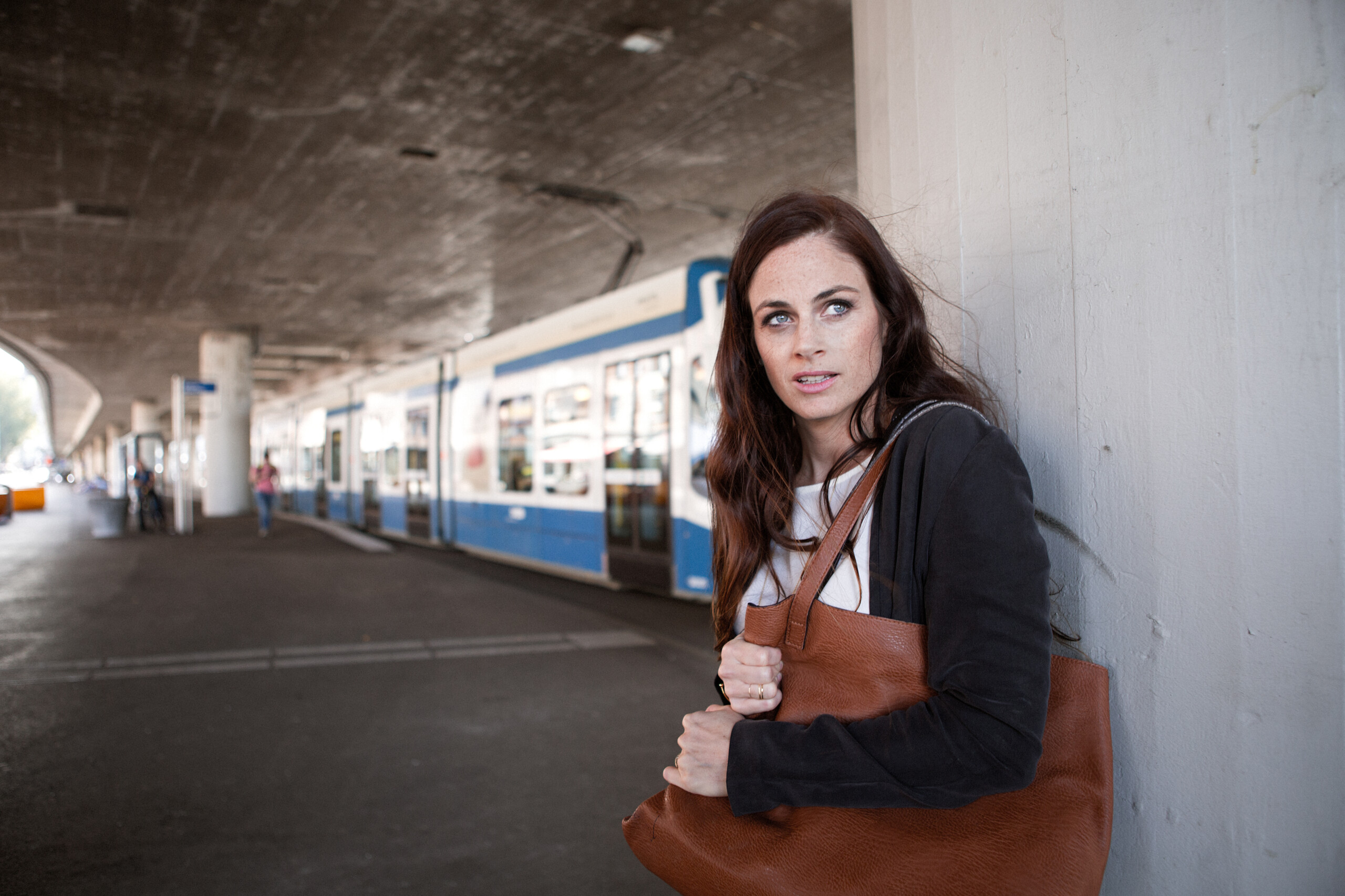 Eine Person steht verängstigt an einer Wand.