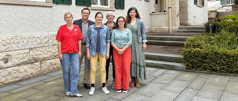 Eine Gruppe von Menschen stehen vor einem Gebäude.